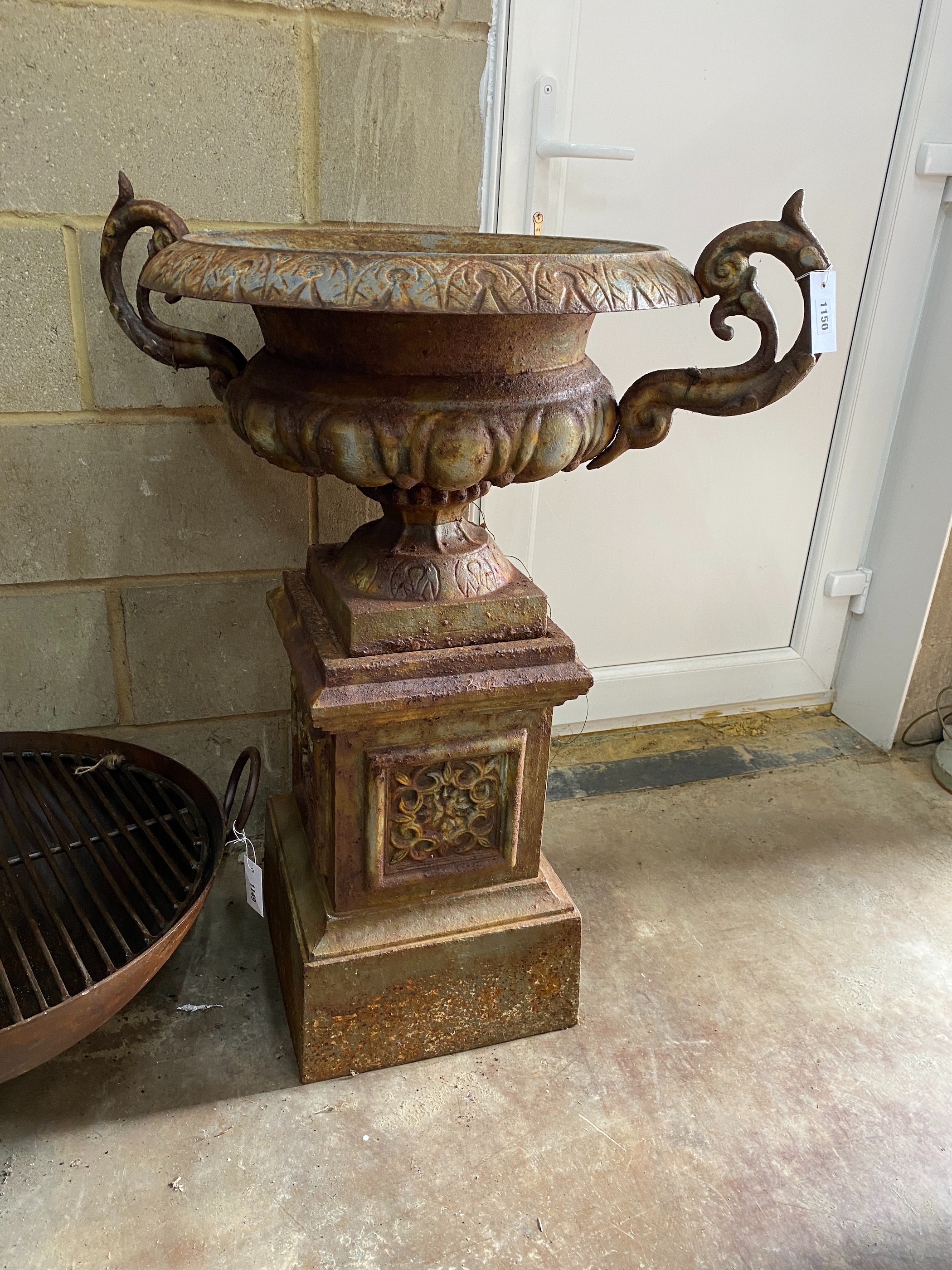 A Victorian style cast iron garden urn on square plinth, width 78cm, height 100cm